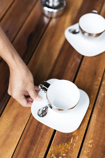 Hand stellt Teetassen auf den Tisch — Stockfoto