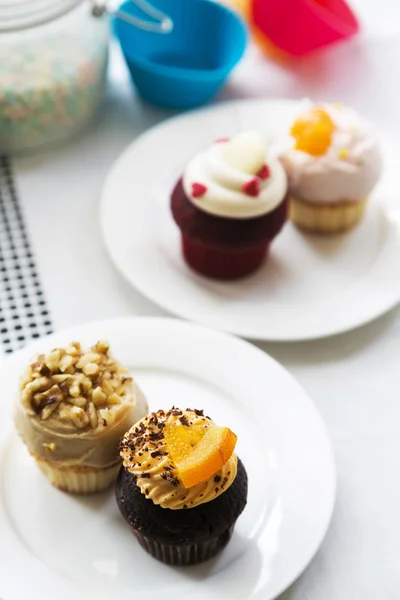 Colorful delicious cupcakes on plates — Stock Photo, Image