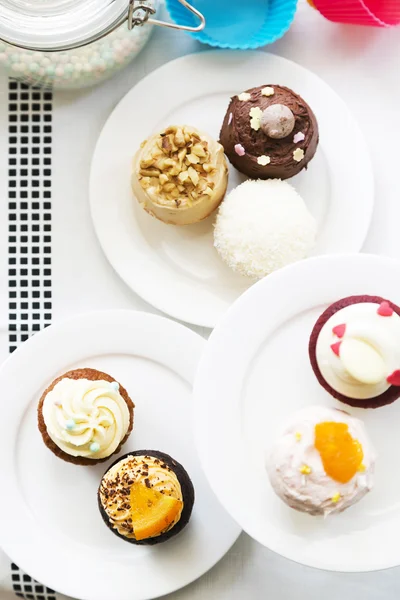 Färgglada läckra muffins på tallrikar, ovanifrån — Stockfoto