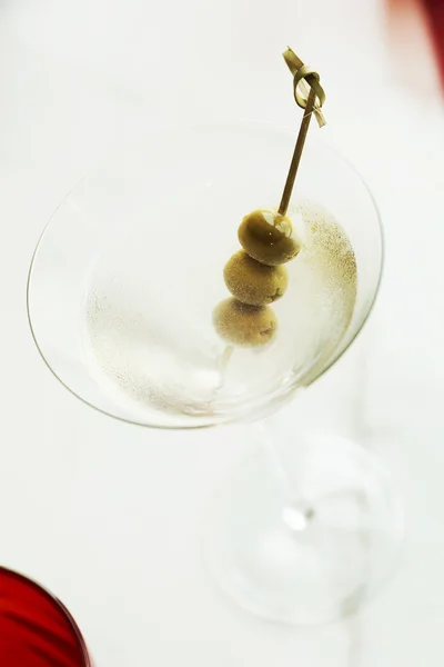 Dry martini med gröna oliver på bord — Stockfoto