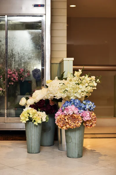 Flores falsas para exhibir en cubos delante del refrigerador — Foto de Stock