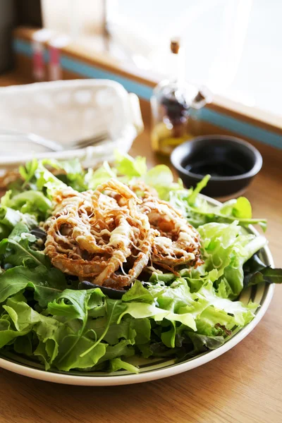 Ensalada deliciosa y saludable con cebolla frita — Foto de Stock
