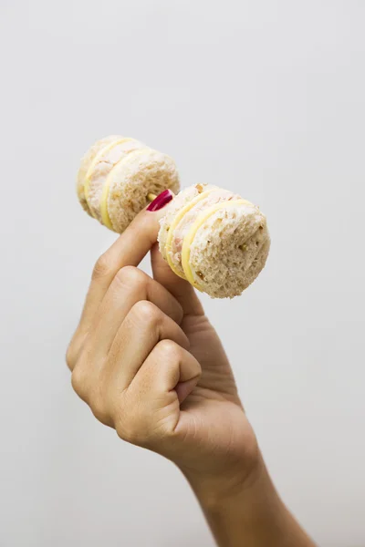 Controle de peso conceito-mão levantando mini sanduíches em haltere — Fotografia de Stock