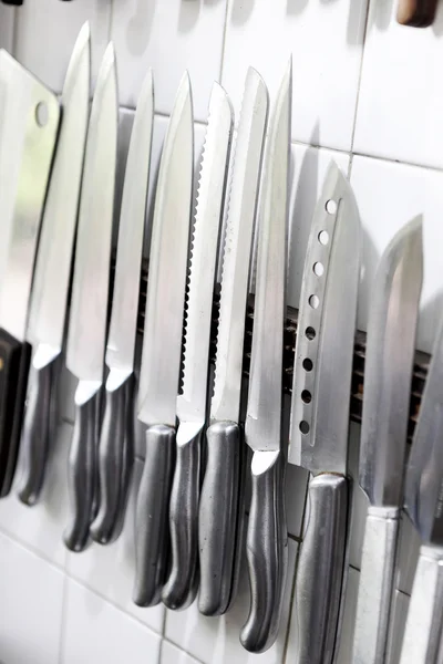 Set of knifes are hanging on a kitchen wall