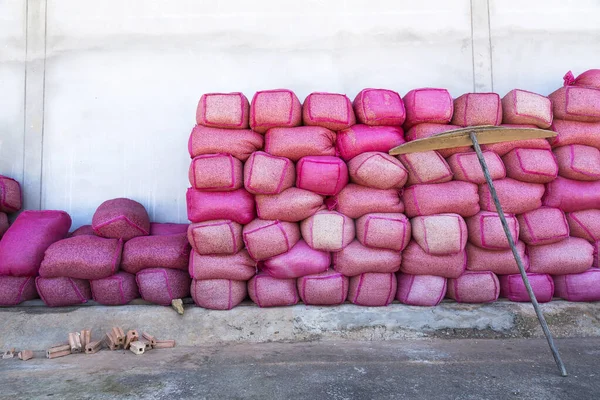 壁の前に積んだピンク色の袋にコーヒー豆 — ストック写真
