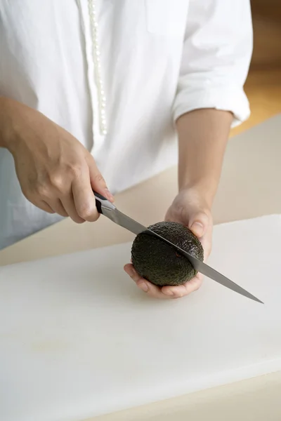 Hand cutting avocado — Stock Photo, Image