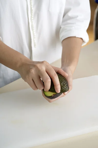 Hand rolling avocado apart — Stock Photo, Image