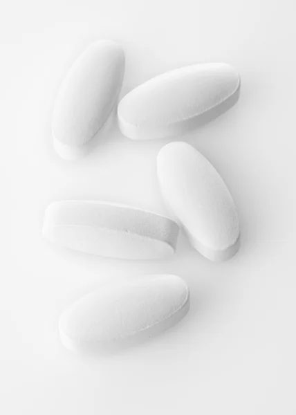 Pillole bianche su sfondo acrilico bianco — Foto Stock