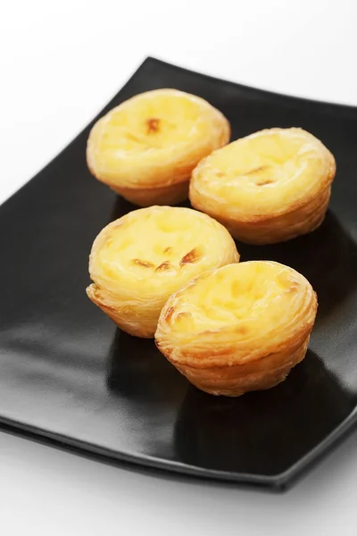 Egg tarts on black plate — Stock Photo, Image