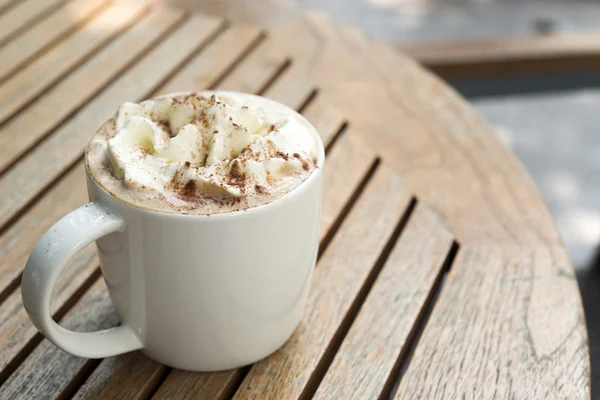 Tasse de garniture au chocolat chaud avec crème à fouetter et poudre de cacao — Photo