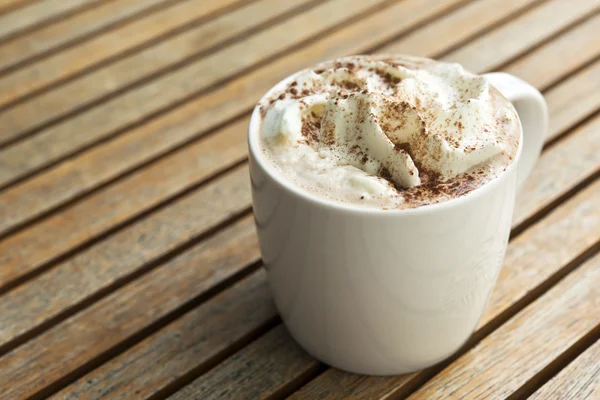 Tasse de garniture au chocolat chaud avec crème à fouetter et poudre de cacao — Photo