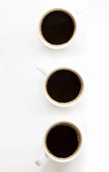 Tres tazas de café sobre fondo de papel — Foto de Stock