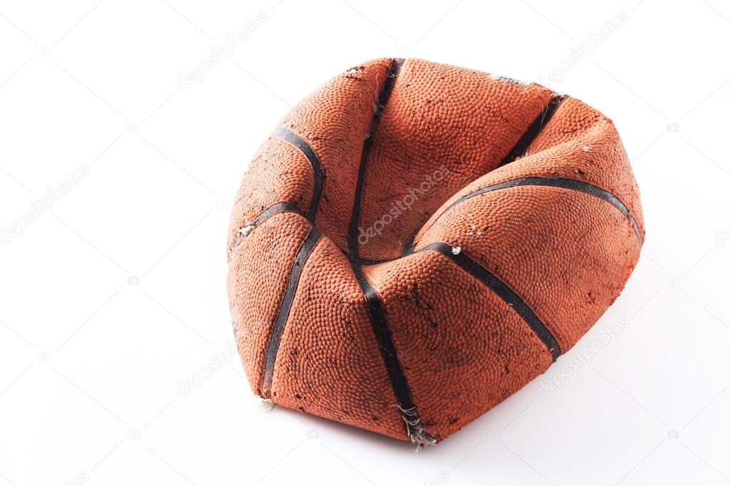 Old damaged rubber basket ball on background