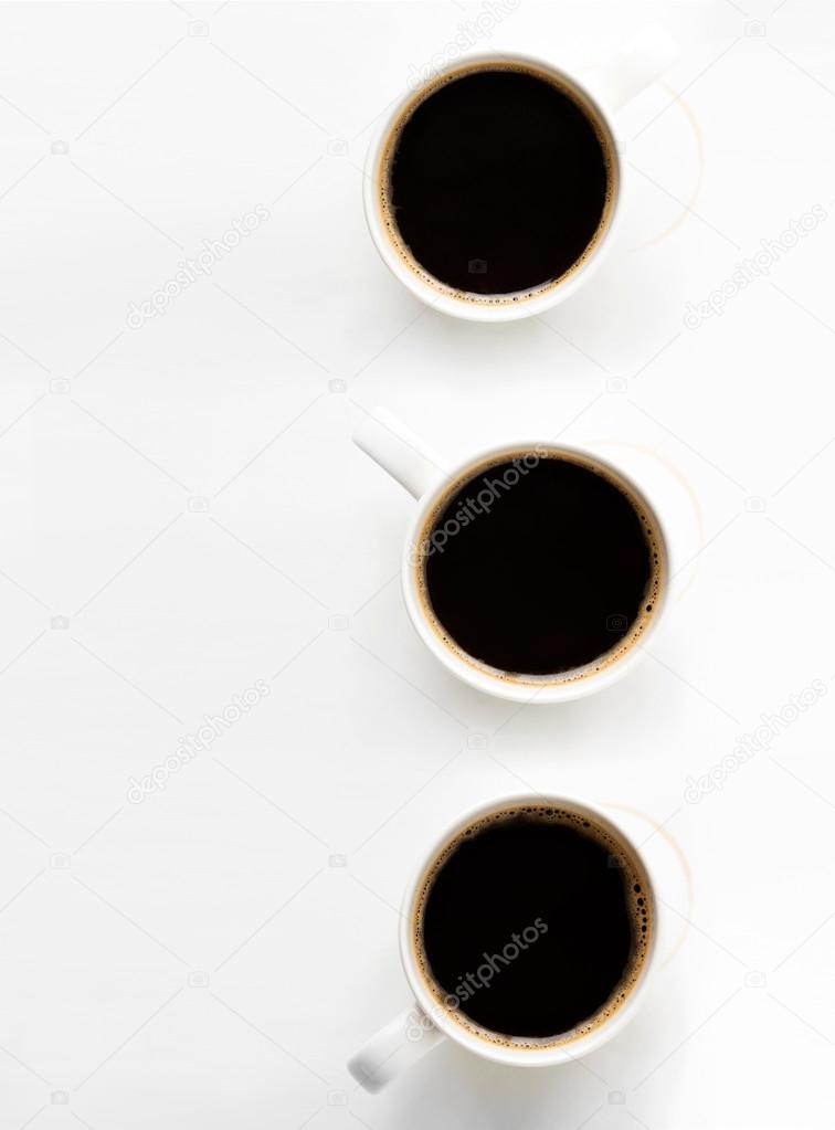 Three cups of coffee on paper background