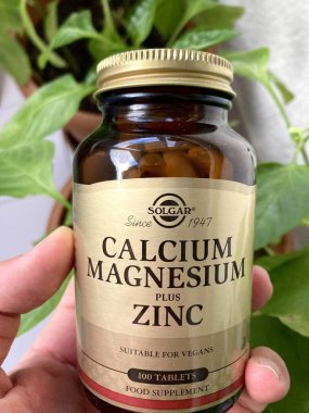 Türkiye - 28 Aralık 2020: Solgar mahnesyum kalsiyum ve çinko takviye şişesi tutan adam