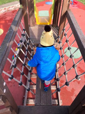 Bebek çocuk parktaki oyun alanında oynuyor.