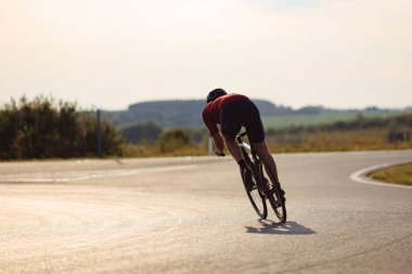 Kasklı ve spor kıyafetli güçlü bisikletçilerin sabah saatlerinde yol bisikleti kullanmaları. Güç ve dayanıklılık kavramı.