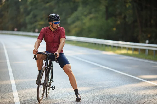Männlicher Athlet Mit Kräftigen Beinen Sportkleidung Entspannt Auf Schwarzem Fahrrad — Stockfoto