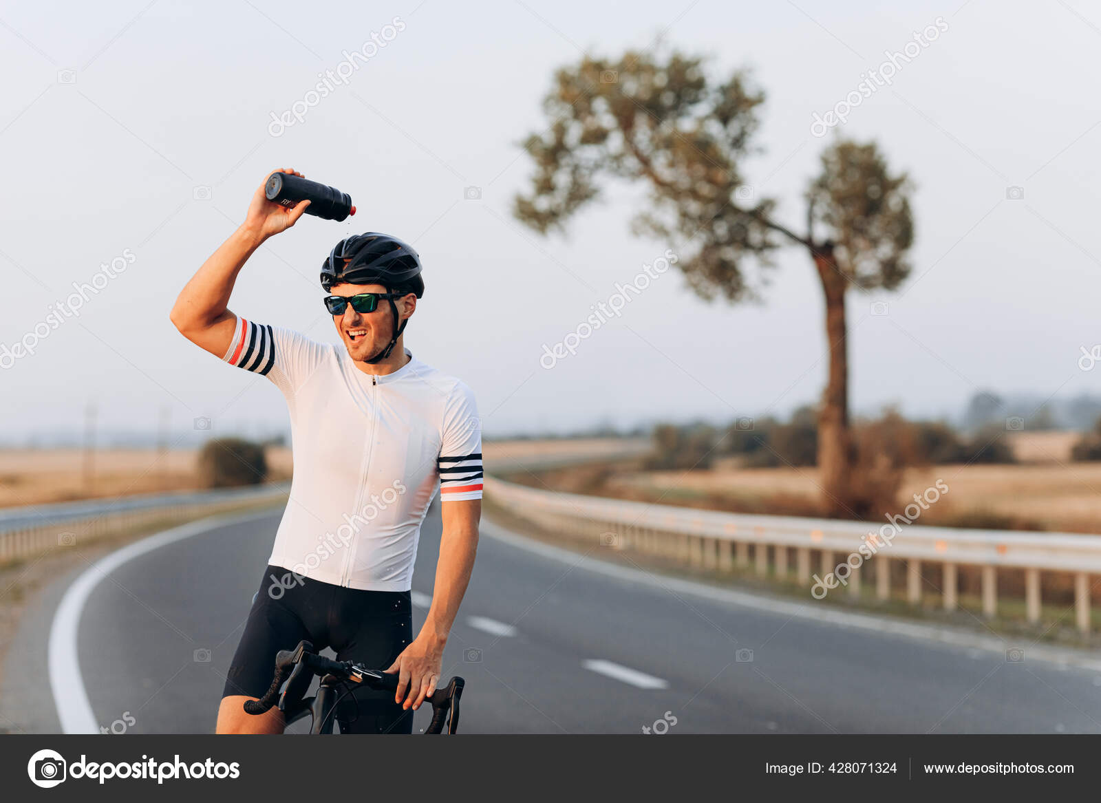 Hombre Caucásico Musculoso Con Casco De Seguridad Y Gafas Espejadas Usando  Bicicleta Negra Para Entrenar Al Aire Libre. Ciclista Pasando El Tiempo De  La Mañana Para Un Entrenamiento Intenso En La Calle