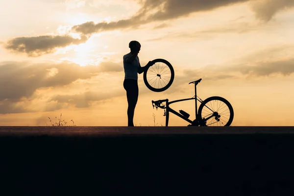 Silhouette Strong Man Helmet Sport Clothing Fixing Wheel Bike Outdoors — Stock Photo, Image