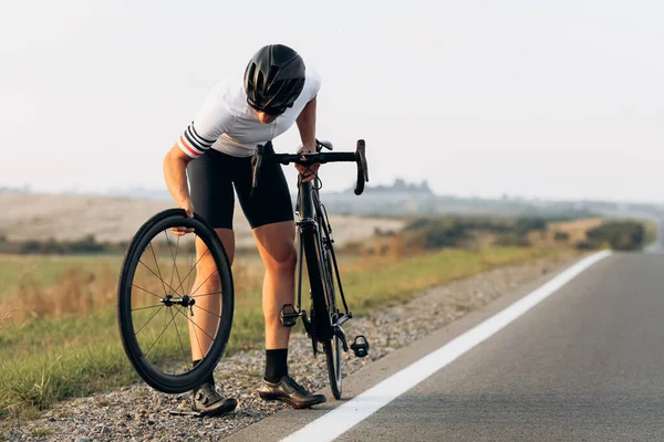 Silny Młody Rowerzysta Odzieży Sportowej Kasku Naprawy Koła Czarny Rower — Zdjęcie stockowe