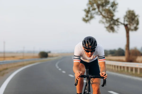 Spor kıyafetleri ve koruyucu kask takan ısrarcı genç adam bisiklette ustalaşmak için sıkı çalışıyor. Motivasyon ve öz disiplin kavramı.