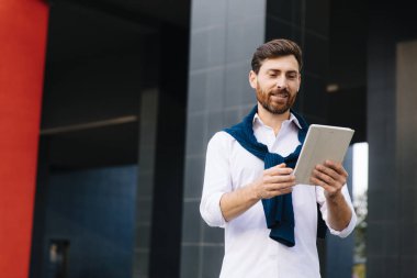 Tablette görüntülü konuşma yapan yakışıklı bir adam.