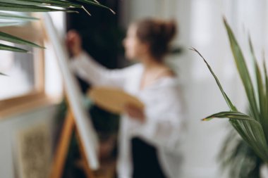 Fırça ve renk paleti olan genç yetenekli ressamın bulanık arkaplanı. Sanat terapisi ve ilham anlayışı.