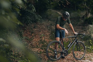 Spor elbiseli, kasklı ve cesaretsiz bisikletçiler açık hava eğitiminden sonra mola veriyor. Sağlıklı beyaz bir adam temiz hava üzerinde çalışmak için boş zaman harcıyor..