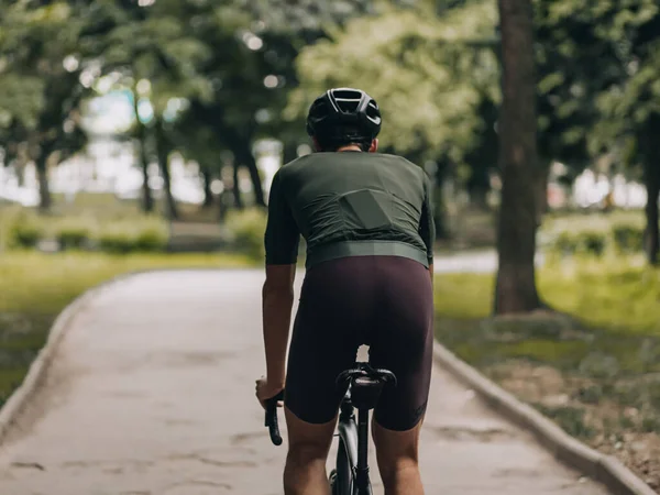 활발히 공원에서 자전거를 다니는 스포츠 선수와 헬멧을 사람의 뒷모습 시간에는 — 스톡 사진
