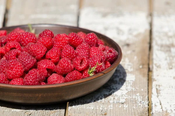 Framboises fraîches mûres dans une assiette d'argile — Photo