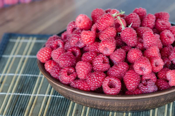 Framboises fraîches mûres dans une assiette d'argile — Photo