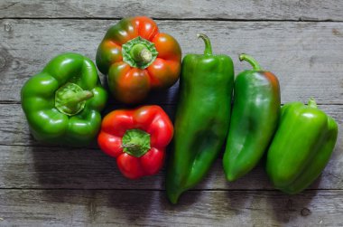 Ahşap zemin üzerine yeşil ve kırmızı biber