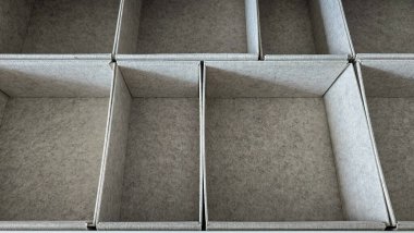 Gri keçeli elbiselerin depolanması için uzay düzenleyicilerinin üst görüntüsü. Sıralama ve düzenleme