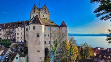 Ortaçağ şatosu Burg Meersburg ve mavi gökyüzünün arka planındaki eski kasaba, Constance Gölü ve İsviçre Alpleri