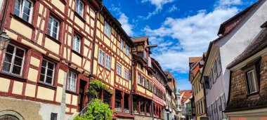 Meersburg, Almanya - Mai 5, 2025. Ortaçağ ahşap çerçeveli çatısı vinçli büyüleyici cadde manzarası.