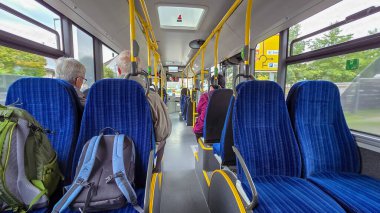 Nussdorf, Uberlingen, Almanya - 27 Eylül 2025. Yolcuları, mavi koltukları ve sarı tırabzanları olan bir Mercedes-Benz Conecto şehir otobüsünün manzarası..