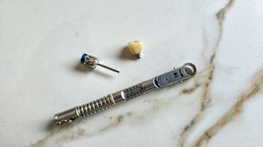 Diş implantı yerleştirmek için aletler ve bileşenler, dişçi anahtarı ve apaçetli seramik kaplama da dahil olmak üzere.