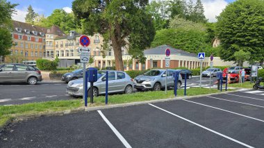 Evaux-les-Bains, Yeni Aquitaine, Fransa - 29 Mayıs 2025. Le Grand Otel manzarası, elektrikli araçlar için park ve şarj istasyonları.