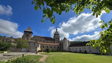 Chambon-sur-Voueize, Creuse Departmanı, Fransa - 29 Mayıs 2025. Ortaçağ manastırı Sainte-Valerie 'nin geniş açılı manzarası. Romanesk kilisesi, açık hava parkı ve yeşil ağaçları var..