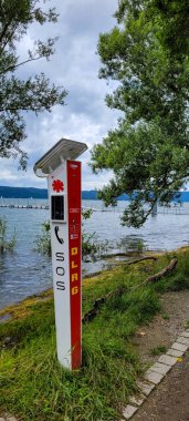 Uberlingen, Almanya - 30 Haziran 2024. Güneş paneli ile DLRG SOS kutbu, su üzerinde acil durum iletişimi için kullanılır. Kutupta bir SOS düğmesi ve kurtarma hizmetleri ile doğrudan iletişim kurmak için bir telefon bulunuyor..