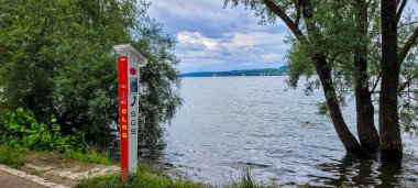 Uberlingen, Almanya - 30 Haziran 2024. SOS düğmeli DLRG SOS direği ve kurtarma ekipleriyle doğrudan iletişim kurmak için bir telefon. Kutupta bir güneş paneli var..