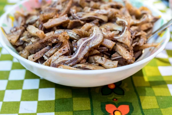 A cooked dish made from pork ears. Delicacy. The dish is on our table.