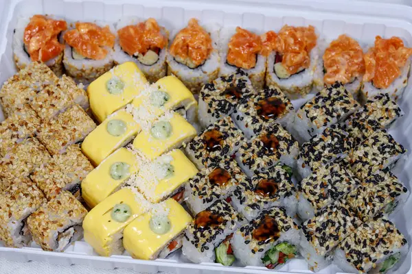 Sushi and rolls home delivery. Krpny plan. Sesame, salmon, cheese. — Stock Photo, Image