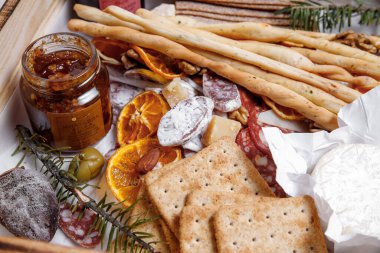 Assortment of snacks in a box isolated on white background. Golden set of exclusive delicacies for a buffet table.