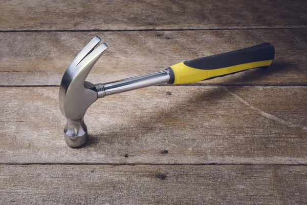 Single handed worn sledge hammer on grunge wood — Stock Photo, Image