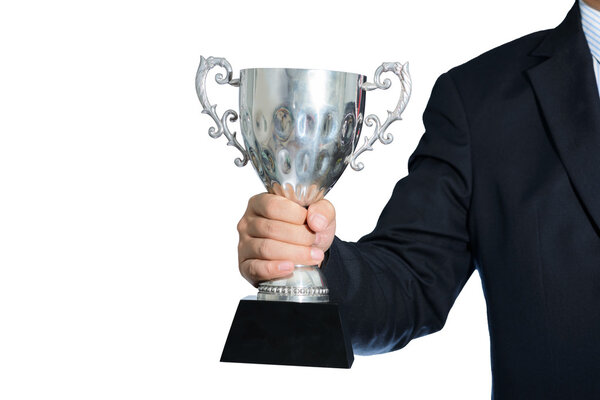 Businessman holding a champion silver trophy on white background