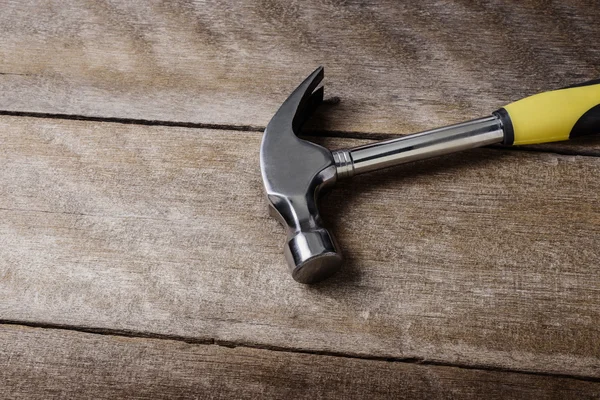 Single handed worn sledge hammer on grunge wood — Stock Photo, Image