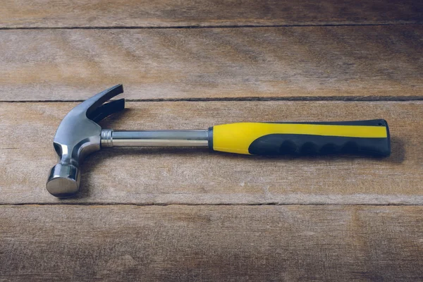 Single handed worn sledge hammer on grunge wood — Stock Photo, Image