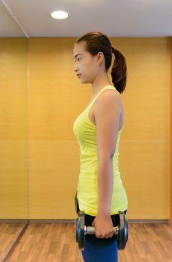 Asansör işi bir spor salonunda kadın dumbbell